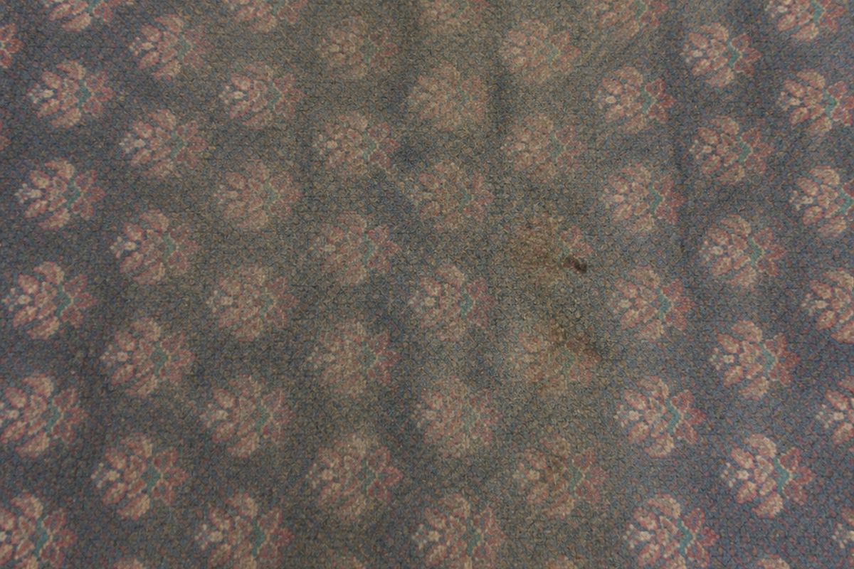 Patterned carpet before cleaning, dulled and marked by foot traffic